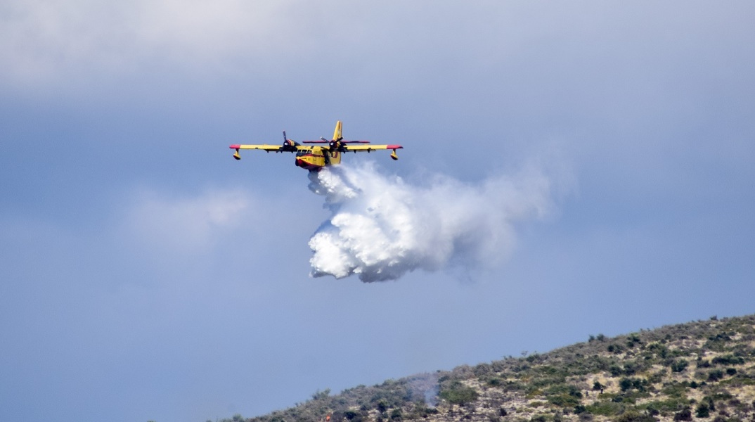 Πυροσβεστικό αεροπλάνο που ρίχνει νερό σε πυρκαγιά
