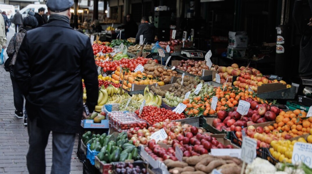 Πολίτης πραγματοποιεί τις αγορές του στην λαϊκή αγορά