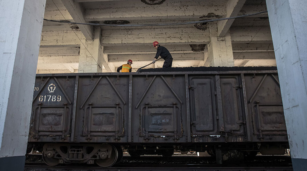 Εργάτες φτιαρίζουν κάρβουνο από βαγόνι τρένου στην Κίνα