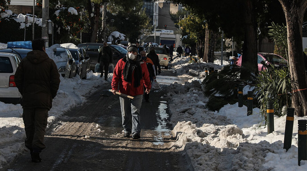 Άνδρας με μάσκα για κορωνοϊό σε δρόμο με χιόνια