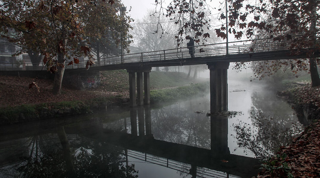 Άνδρας με ομπρέλα σε γέφυρα στα Τρίκαλα