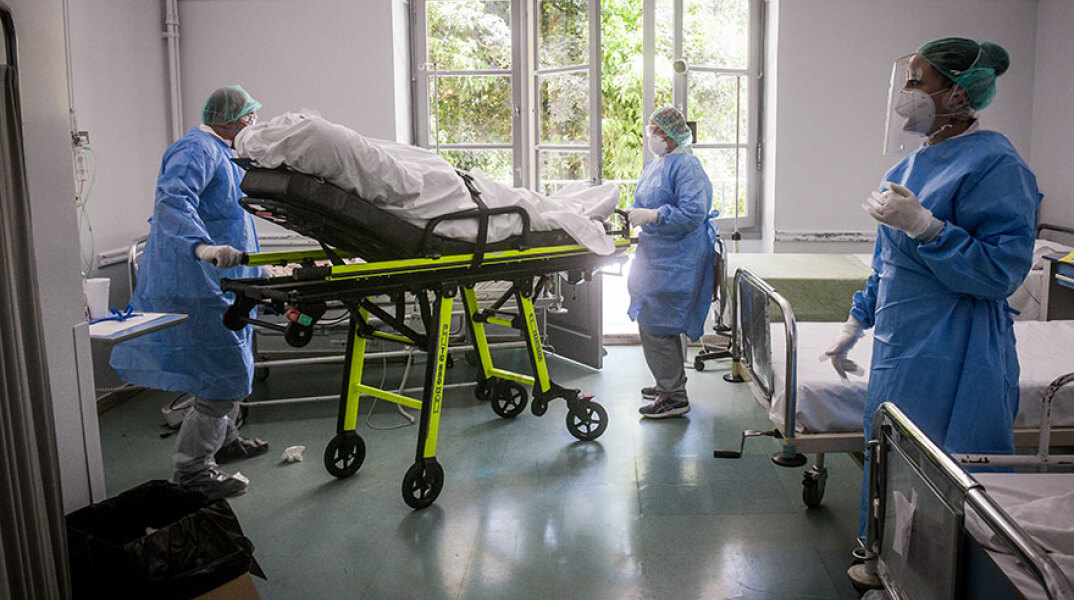 Υγειονομικοί σε νοσοκομείο μεταφέρουν φορείο για ασθενείς με κορωνοϊό