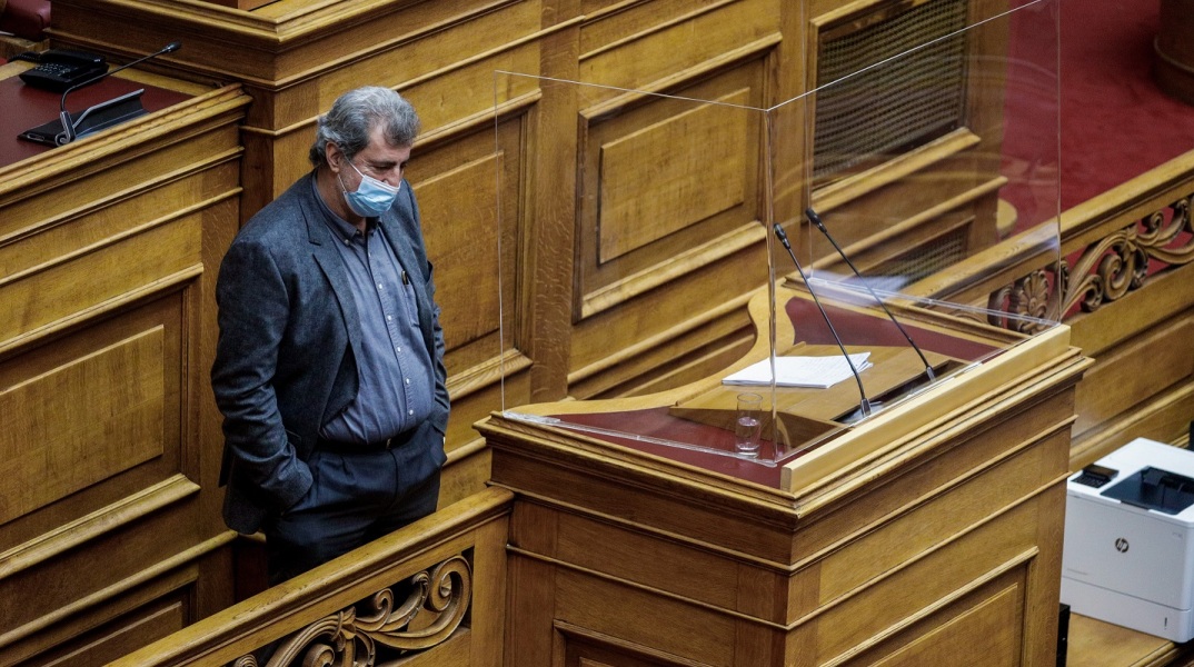 Ο Παύλος Πολάκης με τα χέρια στις τσέπες κοντά στο βήμα της Βουλής