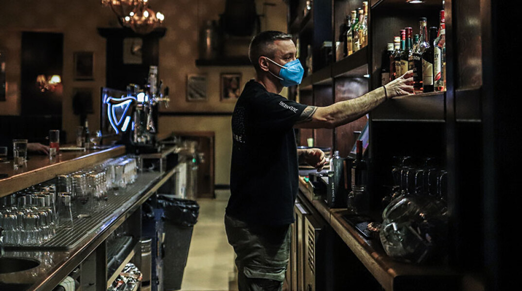 Εργαζόμενος με μάσκα για κορωνοϊό σε καφέ μπαρ στην Αθήνα