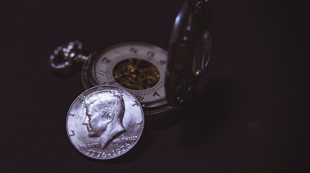 Κέρμα με την όψη του Τζον Φ. Κένεντι δίπλα σε ρολόι