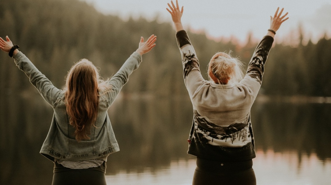 Δύο κορίτσια μπροστά από μια λίμνη. 