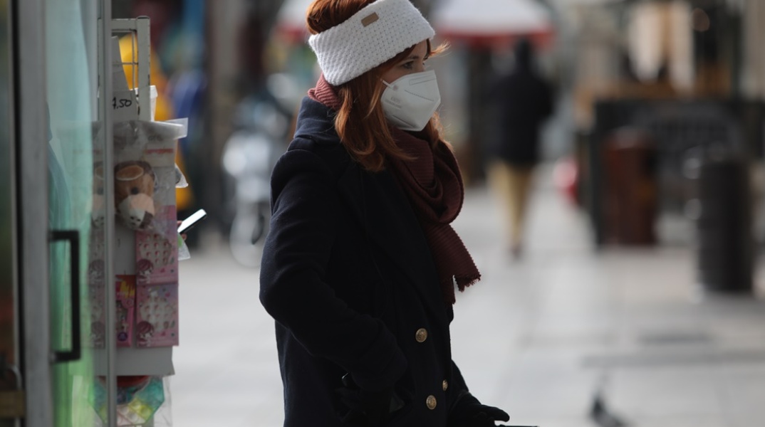 Κρύο - Πτώση θερμοκρασίας - Γυναίκα με σκούφο περπατά στο δρόμο