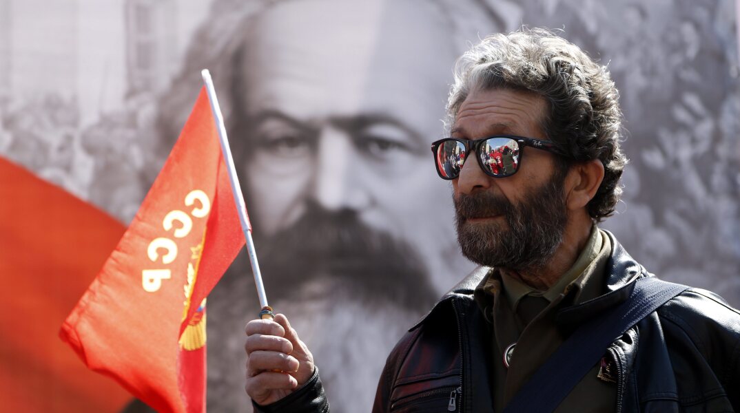 Διαδηλωτής με σημαία του κομμουνιστικού κόμματος στη Ρωσία
