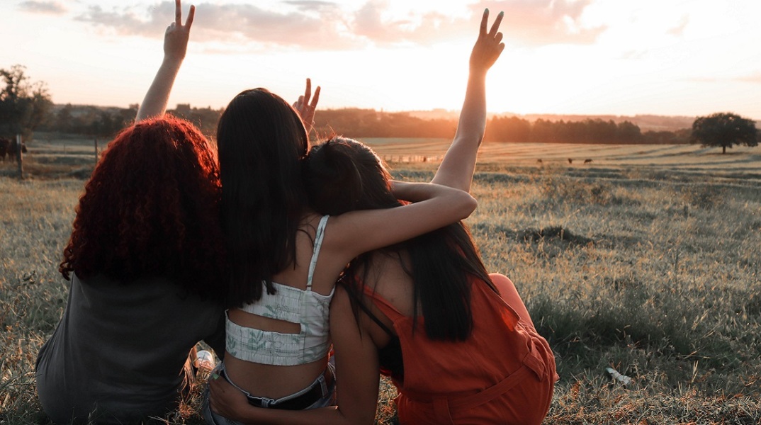 Τρεις φίλες είναι αγκαλιασμένες. 