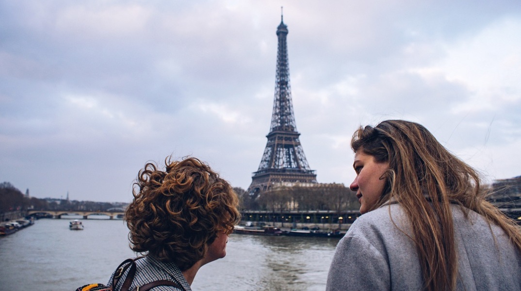 Άνδρας και γυναίκα κοιτούν τον πύργο του Άιφελ στο Παρίσι