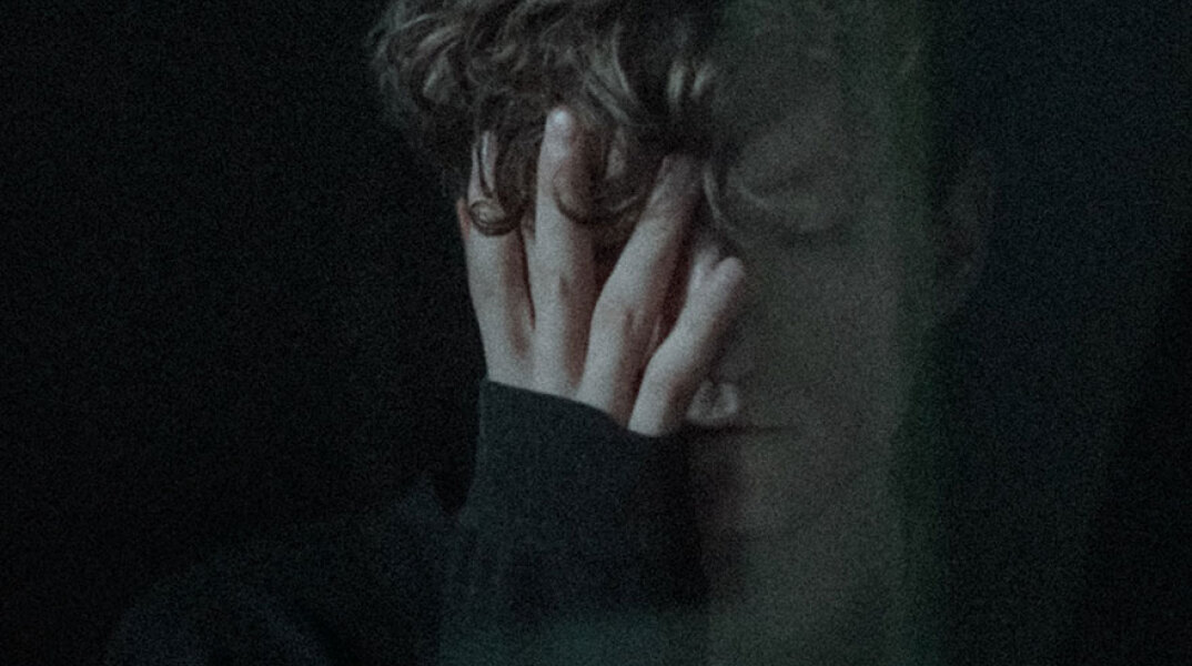 Νέος άντρας που κρύβει το πρόσωπό του