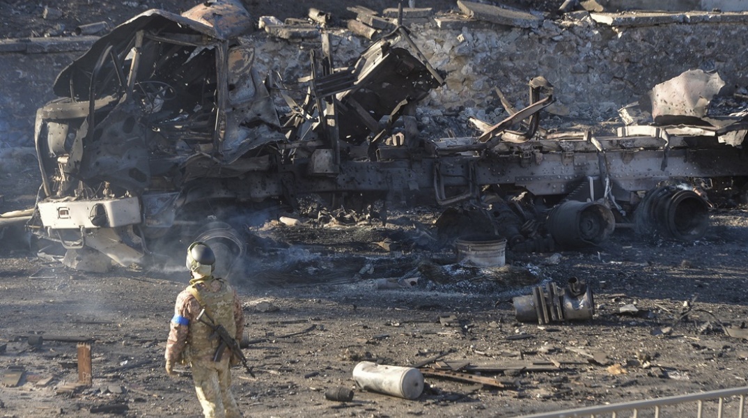 Ουκρανός στρατιώτης στέκεται δίπλα σε βομβαρδισμένο όχημα στην Ουκρανία