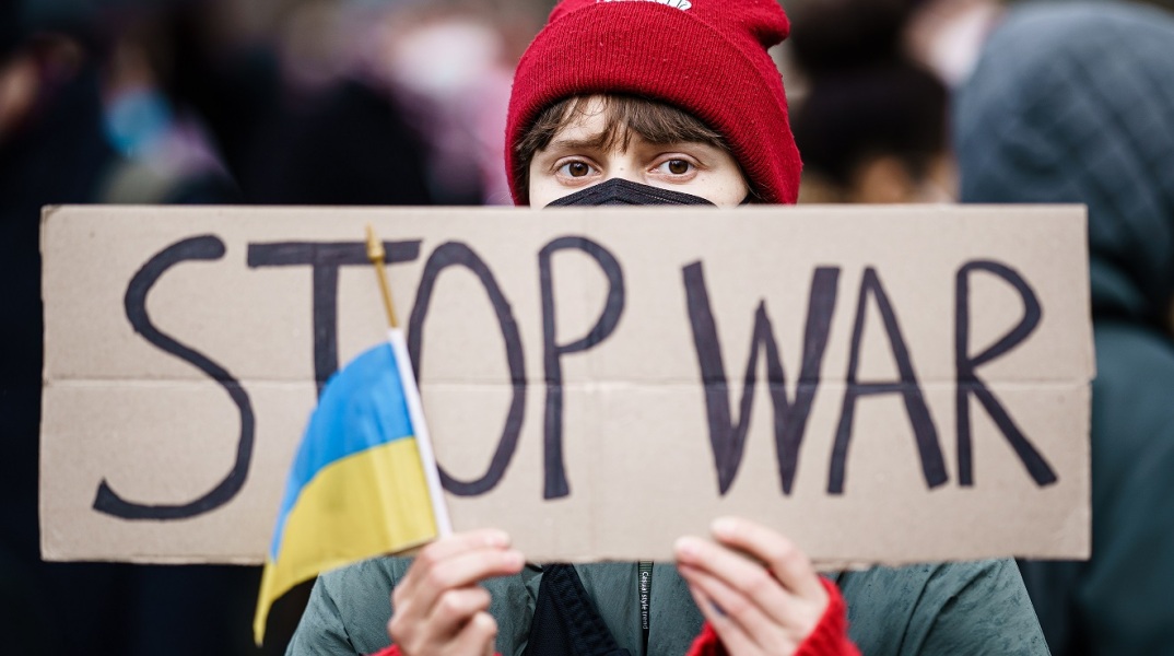 Διαδηλωτής για τον πόλεμο στην Ουκρανία με πλακάτ "Stop the War"