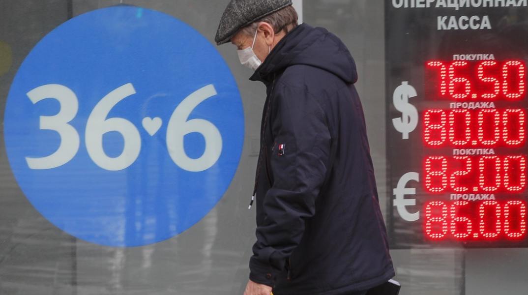 Ρωσία: Άνδρας μπροστά από πίνακα ισοτιμίας για το ρούβλι με το ευρώ