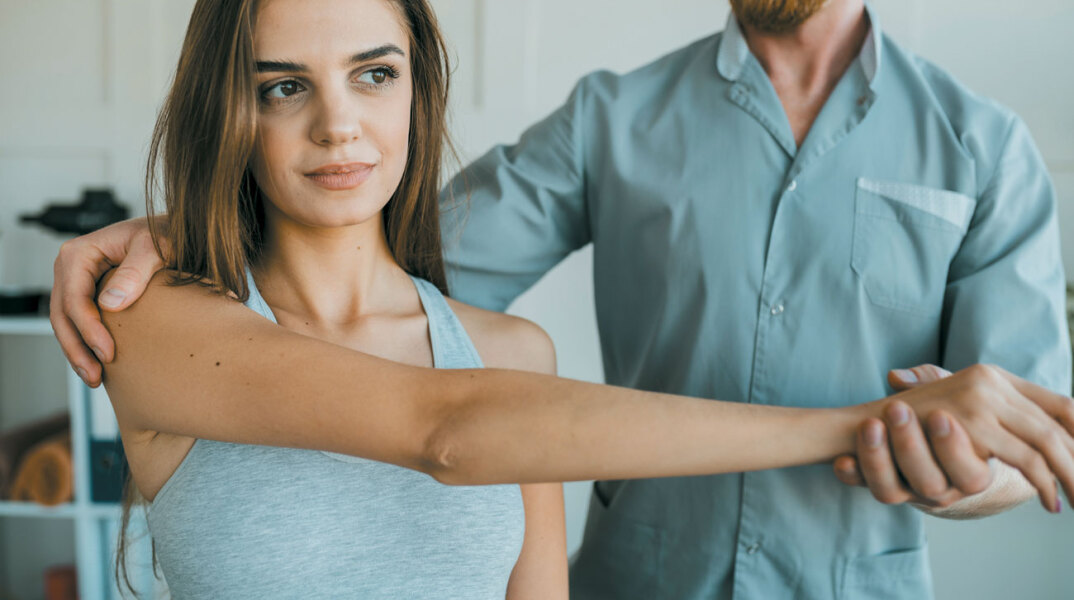 Φυσιοθεραπευτής δείχνει ασκήσεις σε γυναίκα ασθενή