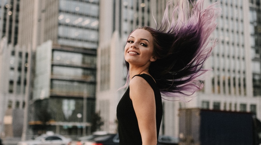 Ένα κορίτσι στο δρόμο χαμογελάει. 