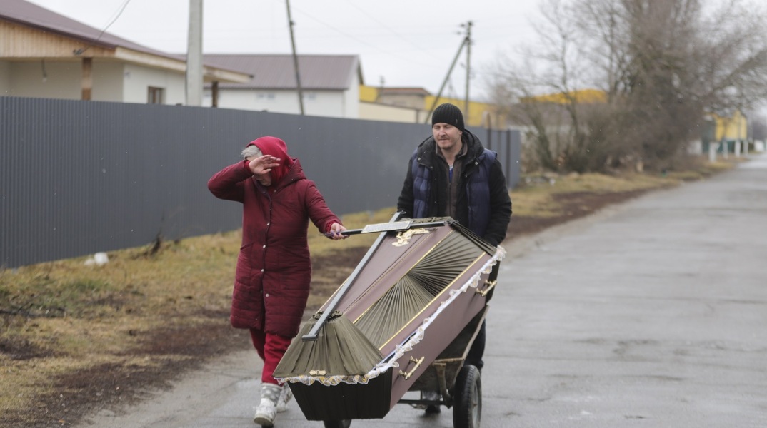Πόλεμος στην Ουκρανία - Άνθρωποι μεταφέρουν φέρετρο με καρότσι
