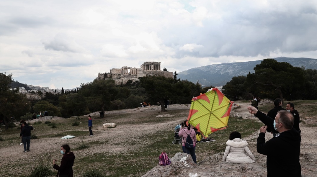 Πολίτες με μάσκα πετούν χαρταετό με φόντο την Ακρόπολη
