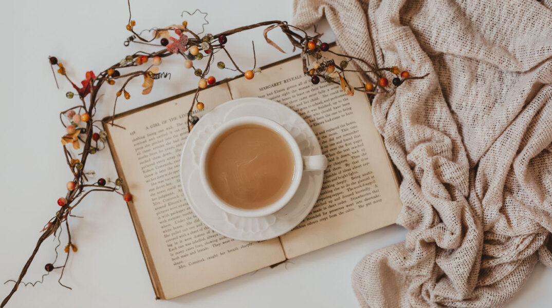 Ανοιχτό βιβλίο με φλιτζάνι καφέ ακουμπισμένο επάνω