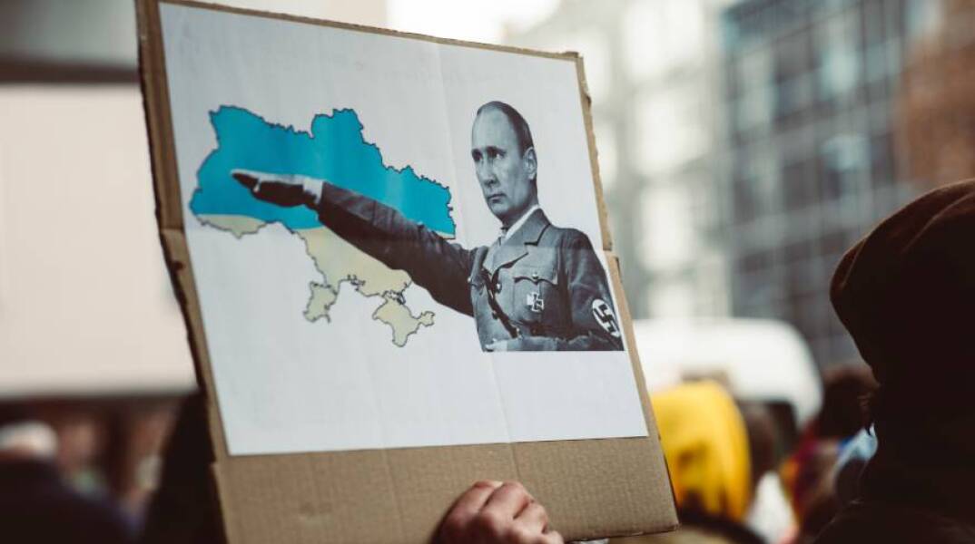 Πλακάτ που προσομοιάζει τον Βλαντιμίρ Πούτιν με τον Αδόλφο Χίτλερ μετά την εισβολή της Ρωσίας στην Ουκρανία