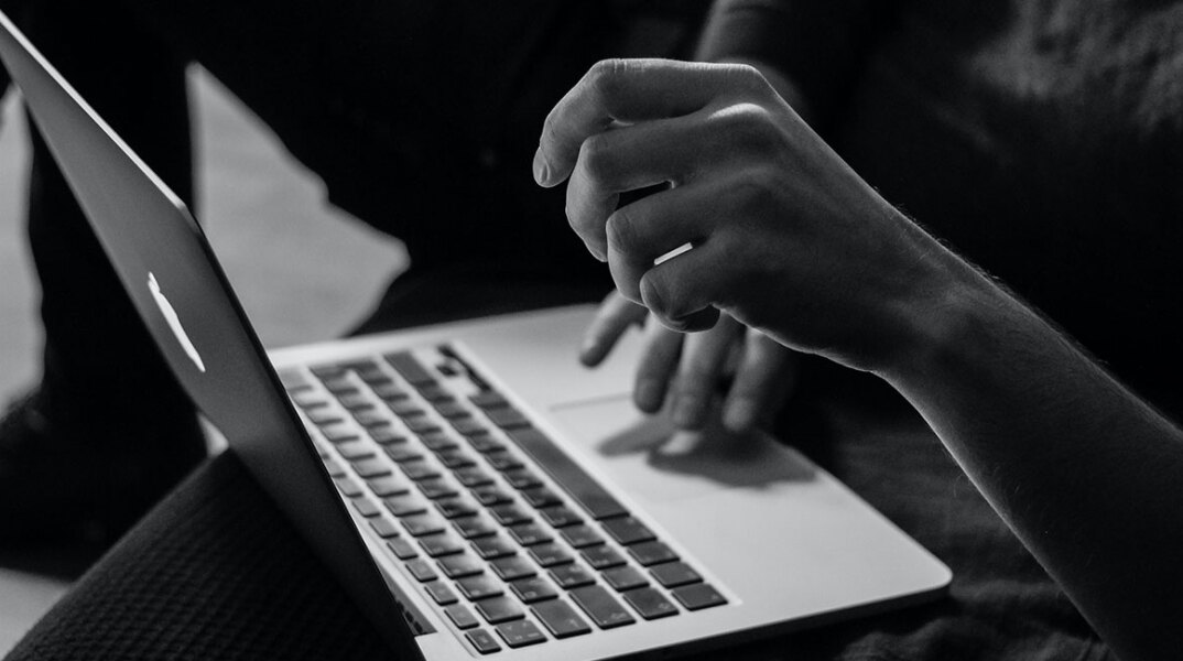 Άντρας με λάπτοπ στα πόδια του