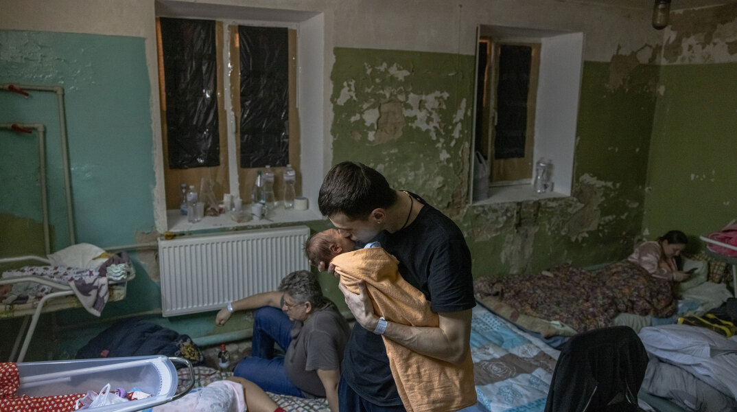Στο Κίεβο πατέρας κρατά στην αγκαλιά το μωρό του σε υπόγειο καταφύγιο