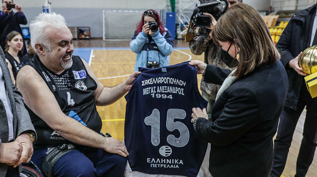 Η Κατερίνα Σακελλαροπούλου δέχεται αναμνηστικό δώρο μετά τον αγώνα μπάσκετ με αμαξίδιο που παρακολούθησε στη Θεσσαλονίκη