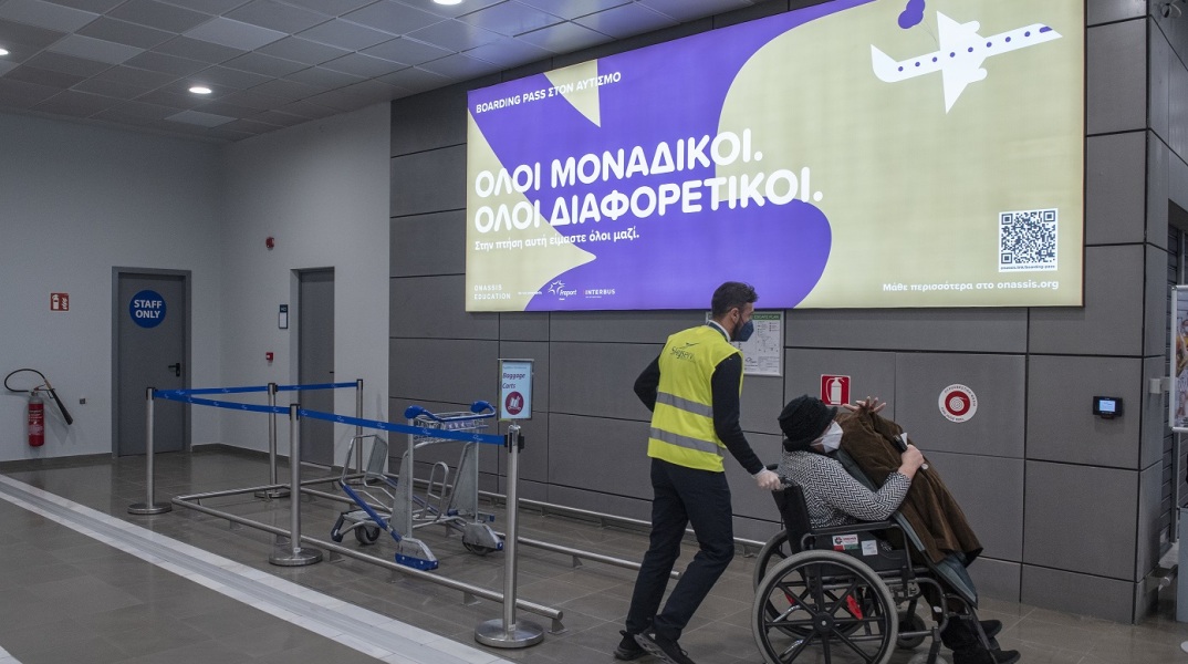 Υπάλληλος σε αεροδρόμιο βοηθά γυναίκα σε αμαξίδιο