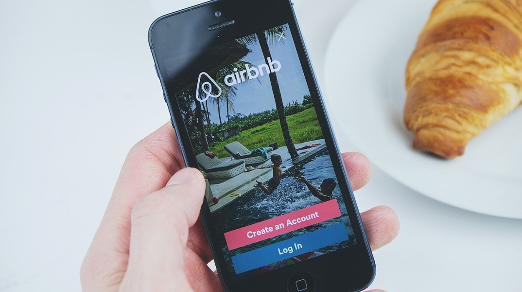 Κινητό τηλέφωνο δείχνει στην οθόνη του την εφαρμογή της Airbnb