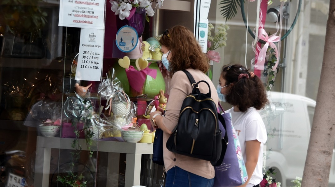 Γυναίκα με μικρό κοριτσάκι κοιτούν στις βιτρίνες εμπορικού καταστήματος - Φορούν και οι δύο Πάσχα