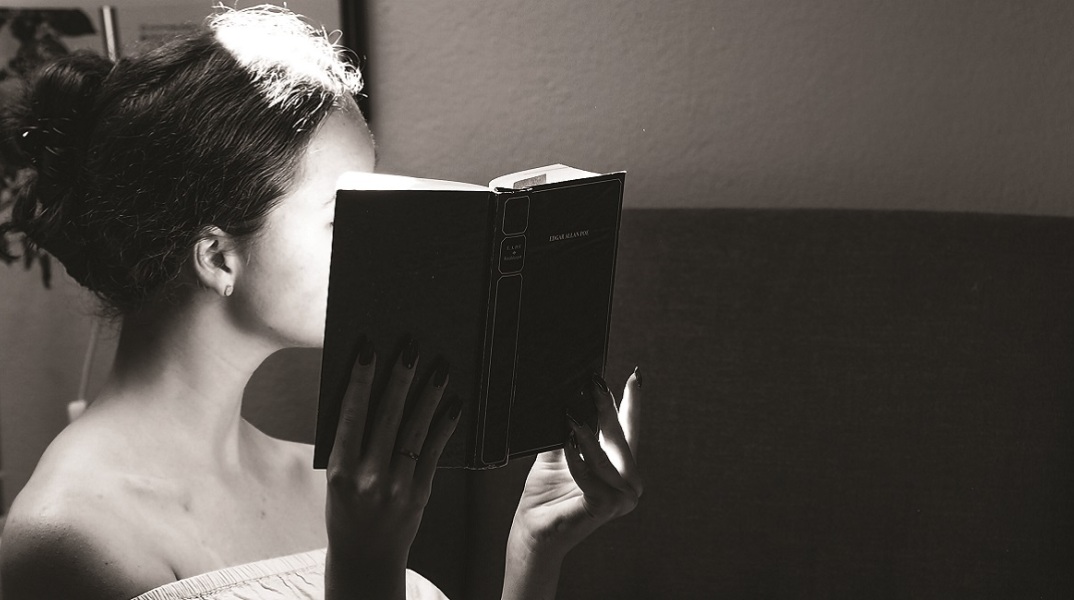 Ένα κορίτσι κρατάει ένα βιβλίο.