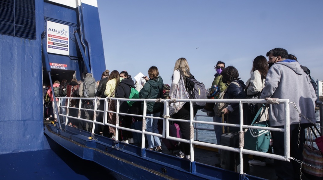 Πολίτες επιβιβάζονται σε πλοίο που αναχωρεί από το λιμάνι του Πειραιά