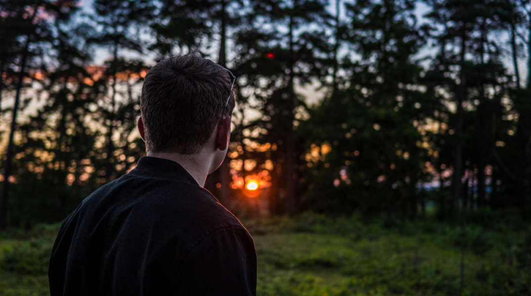 Άντρας που κοιτάει προς το δάσος