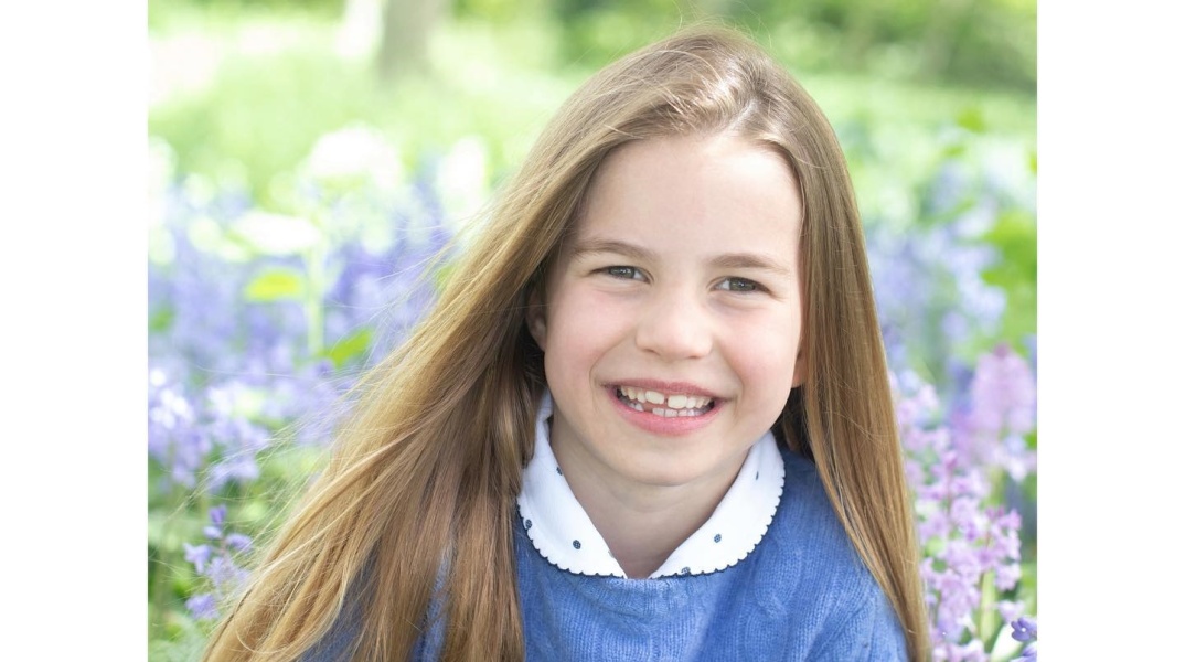 Η πριγκίπισσα Σάρλοτ ποζάρει χαμογελαστή στην Κέιτ Μίντλετον