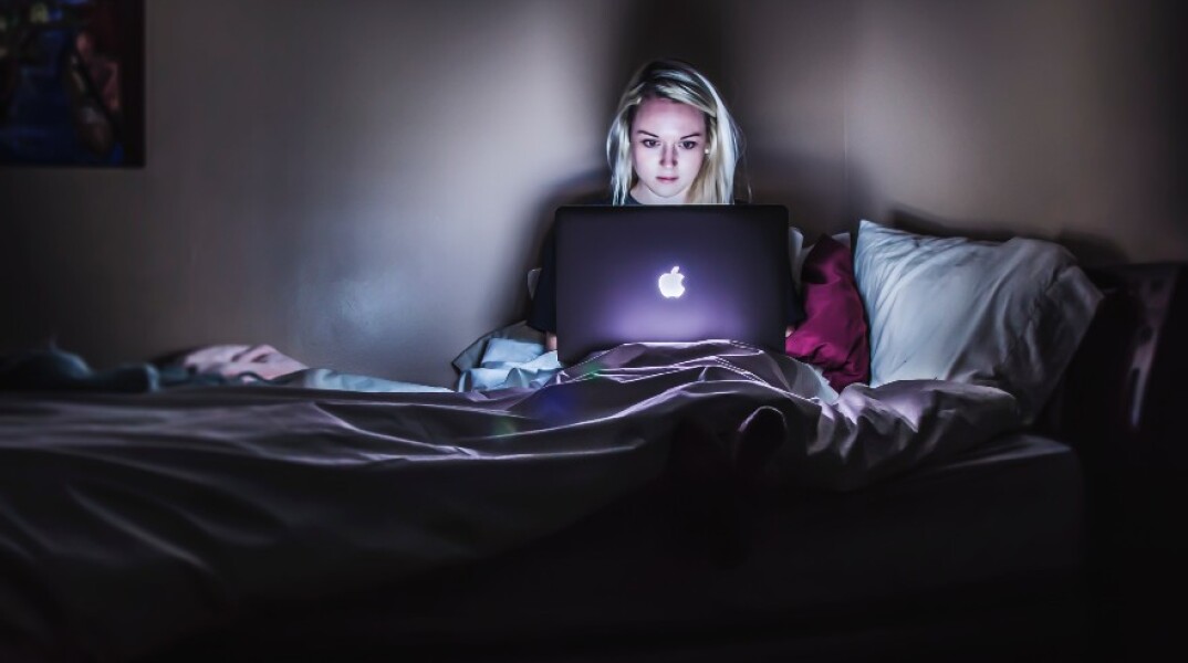 Γυναίκα με υπολογιστή στο κρεβάτι