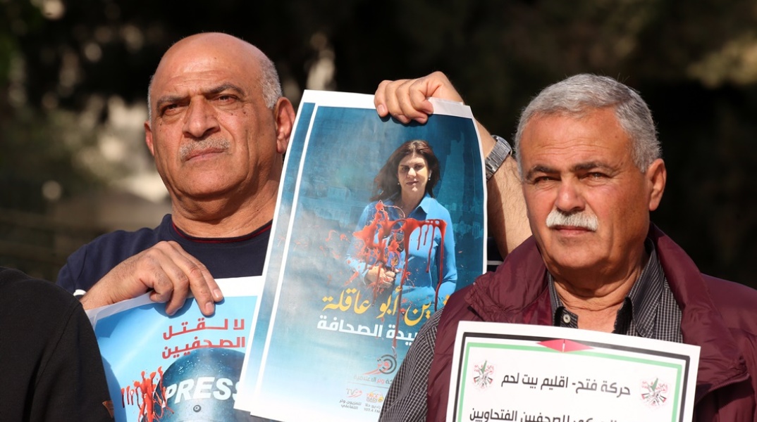 Πολίτες διαμαρτύρονται για τη δολοφονία της δημοσιογράφου του Al Jazeera, Shireen Abu Akleh, κρατώντας φωτογραφίες της