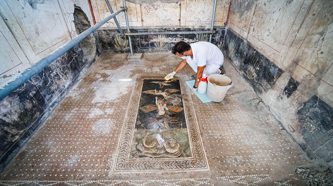 Αρχαιολόγος εκτελεί εργασίες καθαρισμού σε νωπογραφία στην Πομπηία
