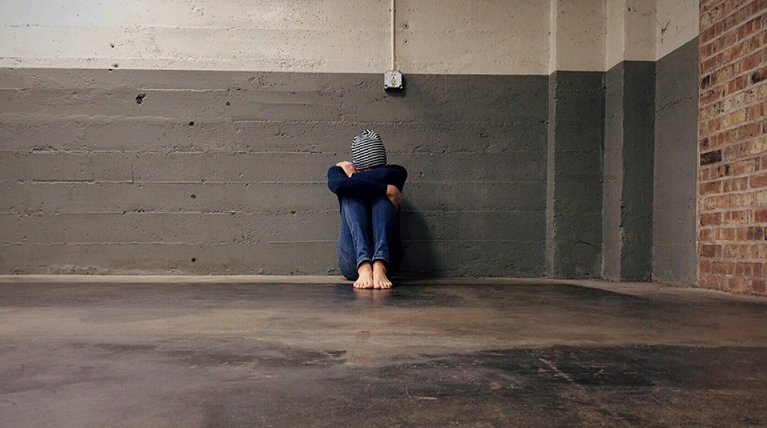 Βία και μοναξιά: Παιδί καθισμένο σε τοίχο