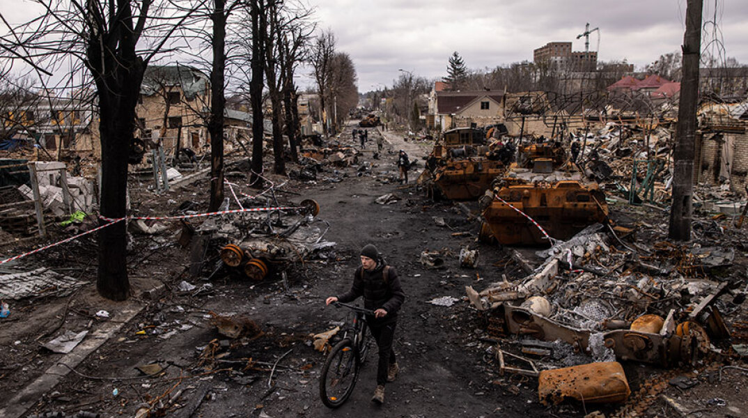 Ποδηλάτης σε διαλυμένο δρόμο στην πολύπαθη πόλη Μπούκα στην Ουκρανία