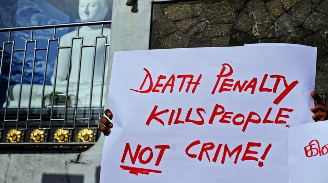 Πλακάτ που γράφει με κόκκινα γράμματα ότι η θανατική ποινή σκοτώνει ανθρώπους, όχι το έγκλημα