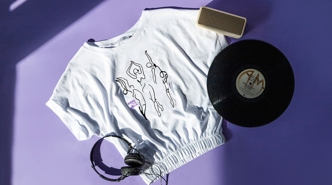 Αντικείμενα (μπλουζάκι, δίσκος βινυλίου, ακουστικά, ηχείο) ακουμπισμένα σε μωβ φόντο