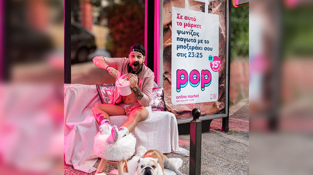 Άνδρας ποζάρει μπροστά σε στάση λεωφορείου, καθισμένος σε πολυθρόνα