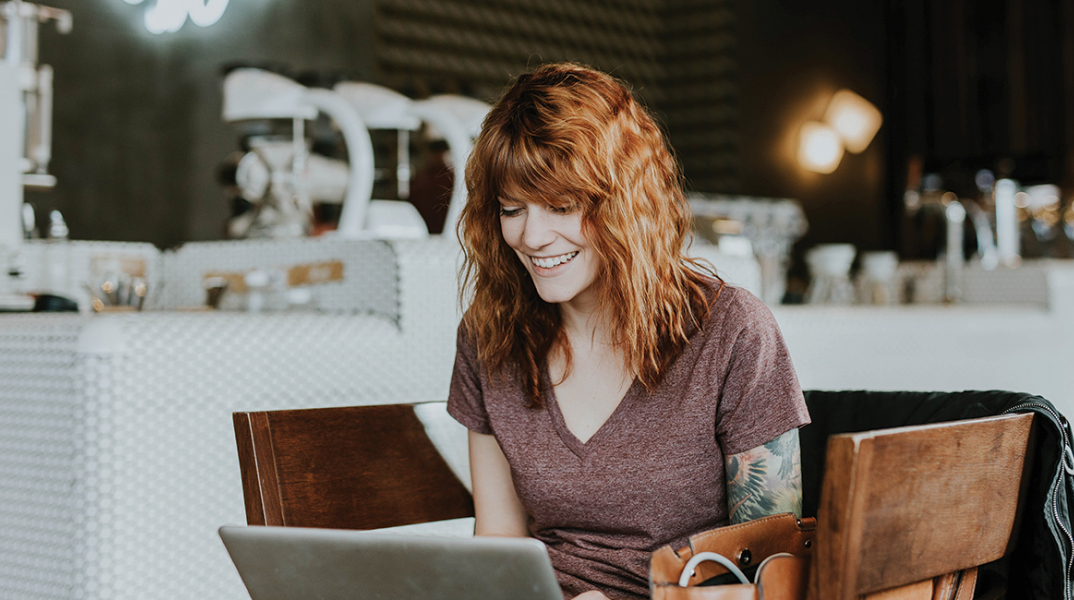 Γυναίκα που δουλεύει από το λάπτοπ της σε καφέ