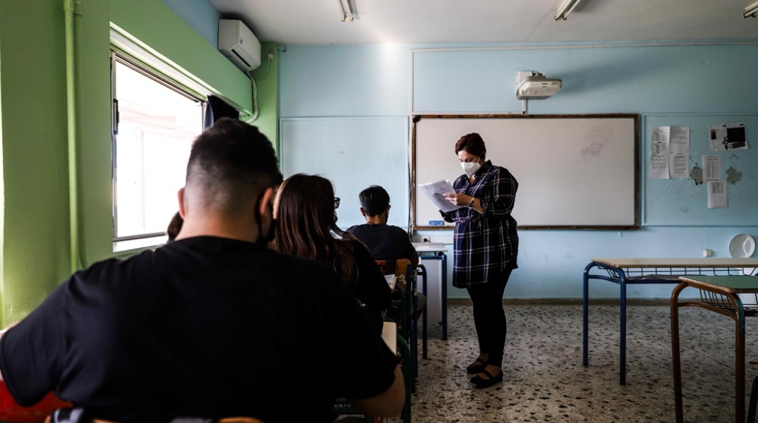 Γυμνάσιο: Μαθητές στην τάξη τους - Η εκπαιδευτικός όρθια φορώντας τη μάσκα της