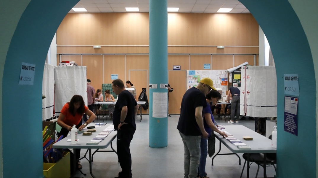Γαλλία - βουλευτικές εκλογές: Ψηφοφόροι στέκονται μπροστά από τις κάλπες και ασκούν το εκλογικό τους δικαίωμα