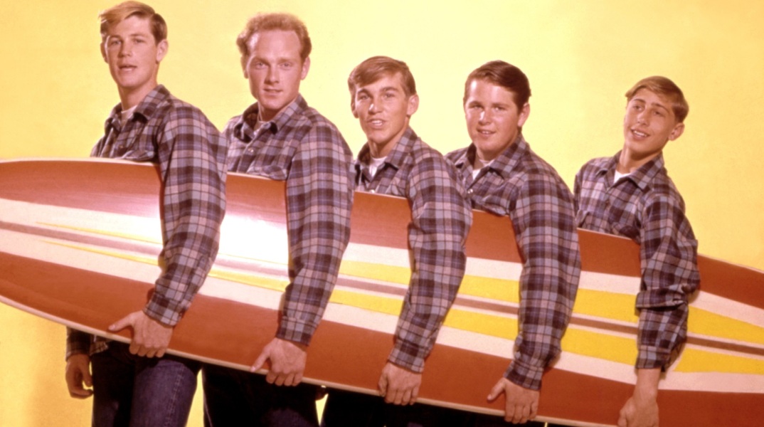 Το συγκρότημα The Beach Boys ποζάρει κρατώντας μια σανίδα σερφ