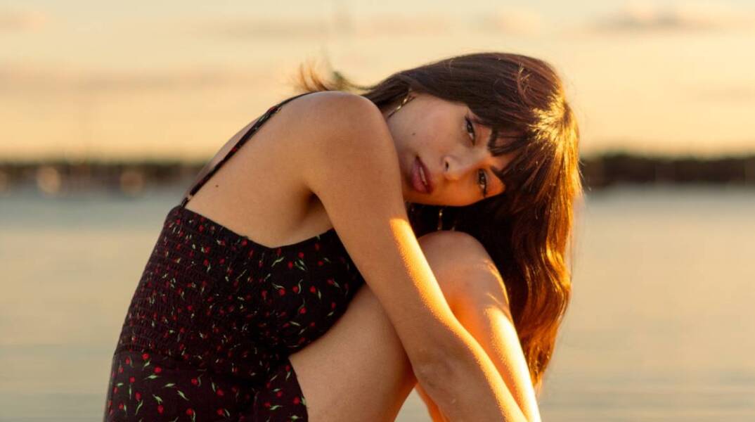 Νεαρή κοπέλα που κάθεται στην προβλήτα