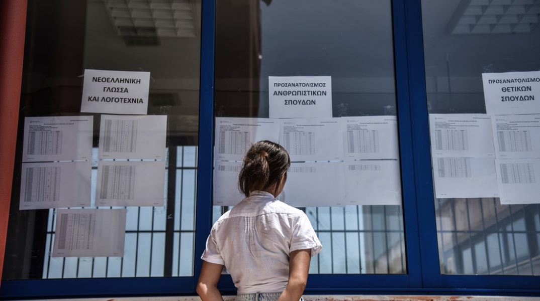 Αποτελέσματα Πανελληνίων 2022 - Γυναίκα μπροστά από τις αναρτημένες βαθμολογίες