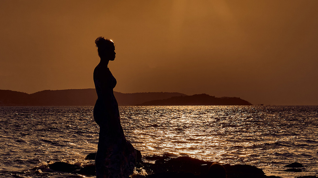 Ένα κορίτσι ποζάρει στο ηλιοβασίλεμα. 