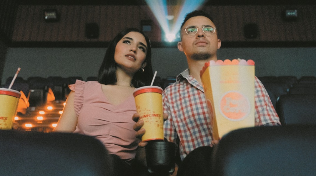 Δύο άτομα βλέπουν μια ταινία στον κινηματογράφο.